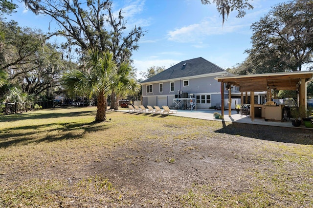 back of property featuring a garage, a patio, a lawn, and fence