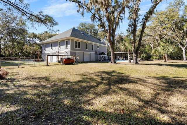 exterior space with an attached garage, fence, and a yard