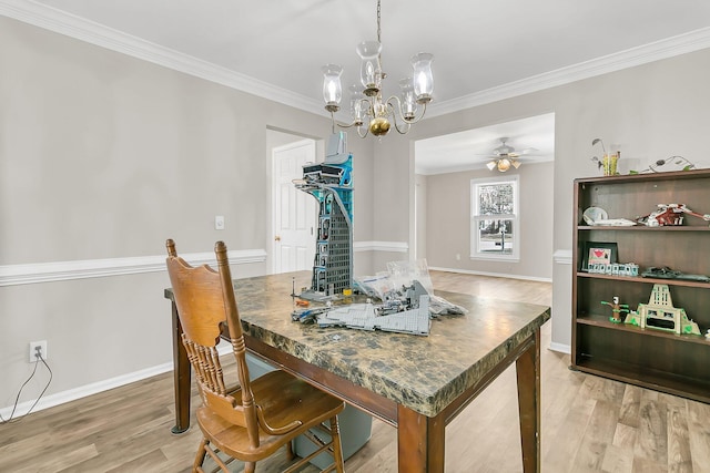 dining room with hardwood / wood-style flooring, crown molding, and ceiling fan with notable chandelier