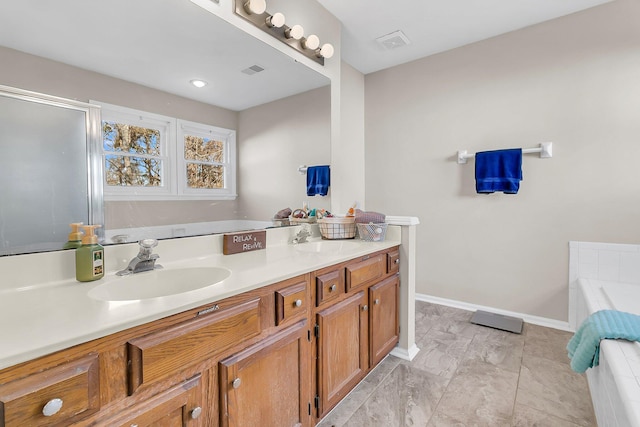 bathroom featuring vanity and tiled tub