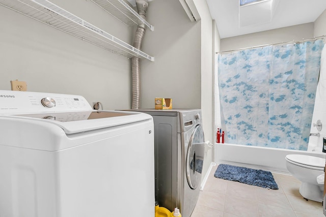 clothes washing area featuring washing machine and clothes dryer and light tile patterned floors