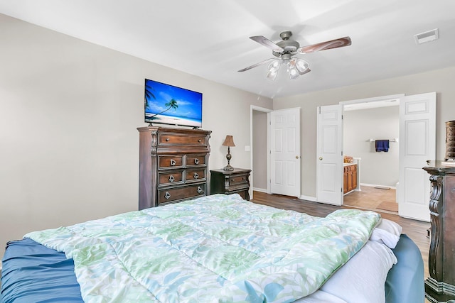 bedroom with connected bathroom, light hardwood / wood-style floors, and ceiling fan