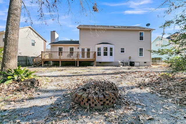 rear view of property with a wooden deck, a fire pit, and central AC