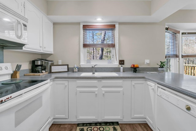 kitchen with dark wood-type flooring, white appliances, sink, and white cabinets