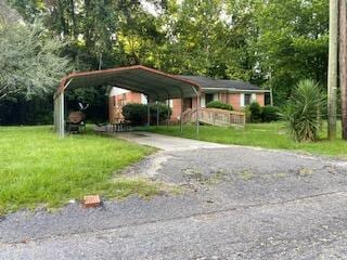 104 Harvin Ave, Manning, SC 29102 - view of vehicle parking featuring a carport and a yard