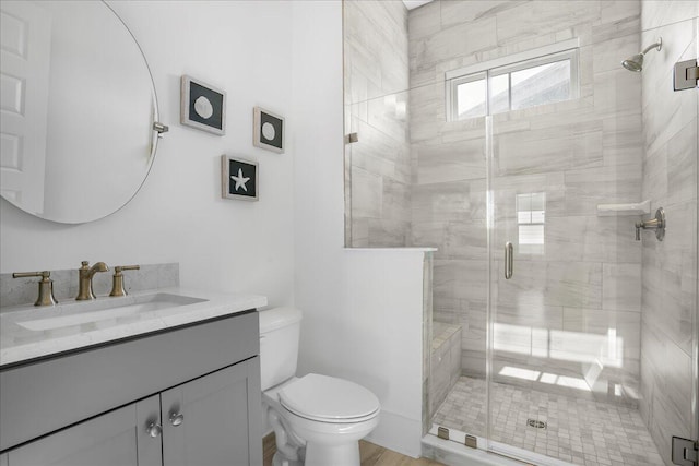 bathroom featuring wood-type flooring, vanity, toilet, and walk in shower