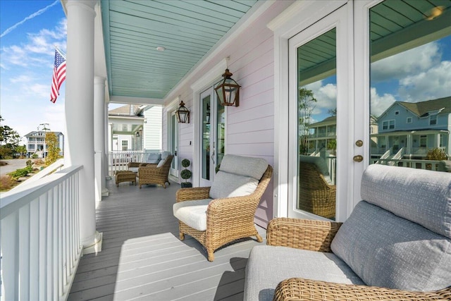 wooden terrace featuring covered porch and french doors