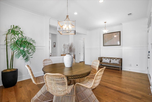 dining room featuring a decorative wall, a chandelier, ornamental molding, recessed lighting, and wood finished floors