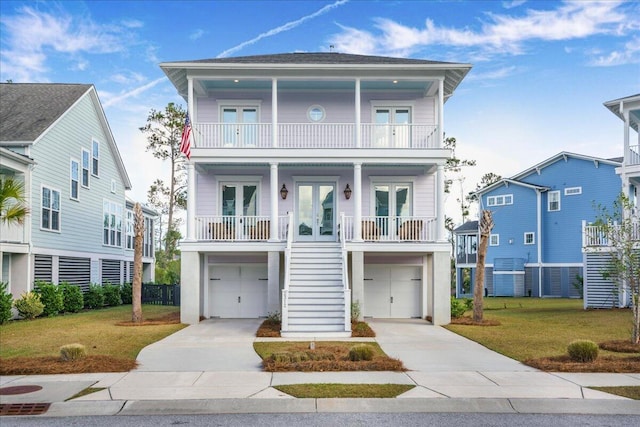 coastal home with covered porch, french doors, a balcony, and a front lawn