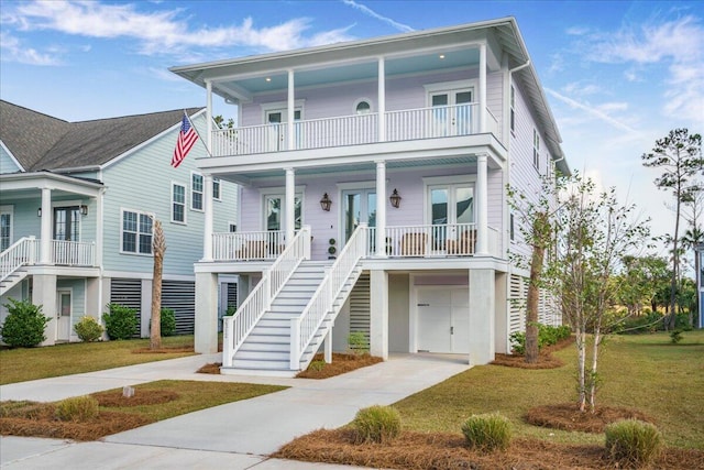 coastal inspired home featuring a porch, french doors, and a front yard