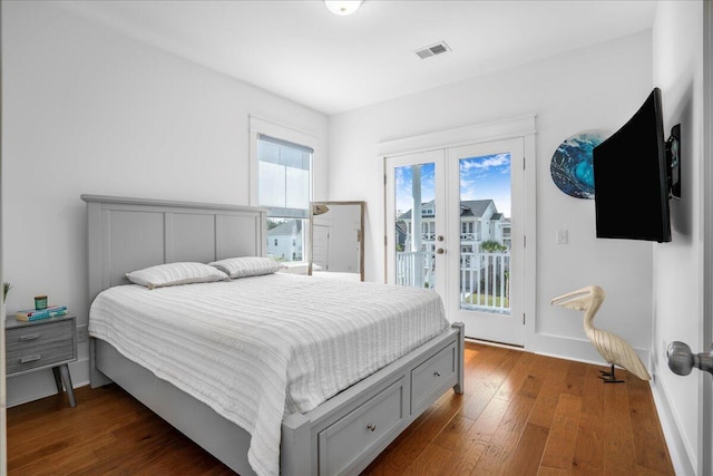 bedroom with access to exterior, wood finished floors, and french doors