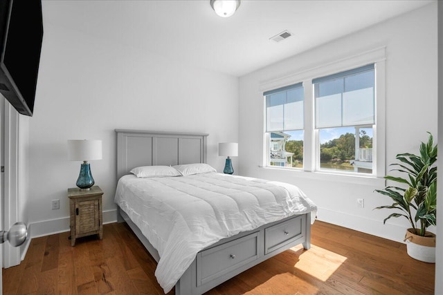 bedroom with dark wood-style flooring and baseboards