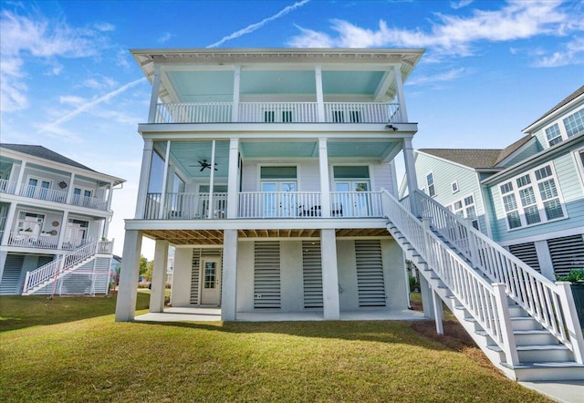 rear view of property featuring a lawn, ceiling fan, and a balcony