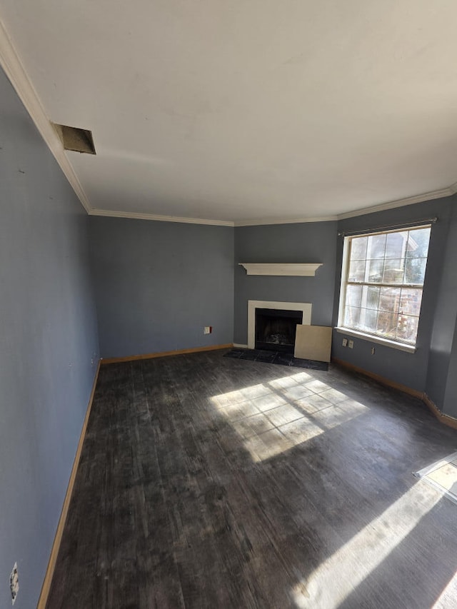 unfurnished living room featuring a fireplace, crown molding, baseboards, and wood finished floors