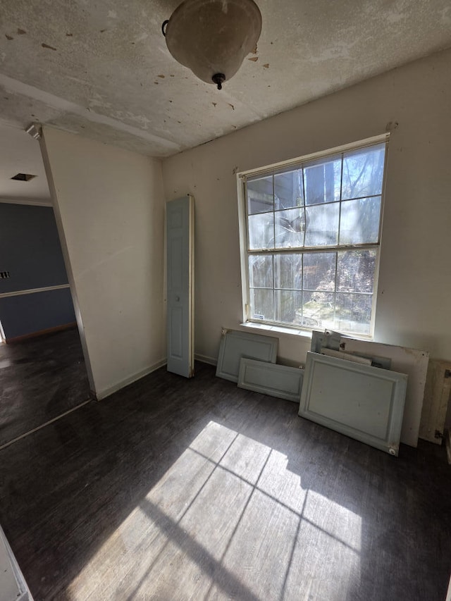 interior space featuring baseboards and wood finished floors