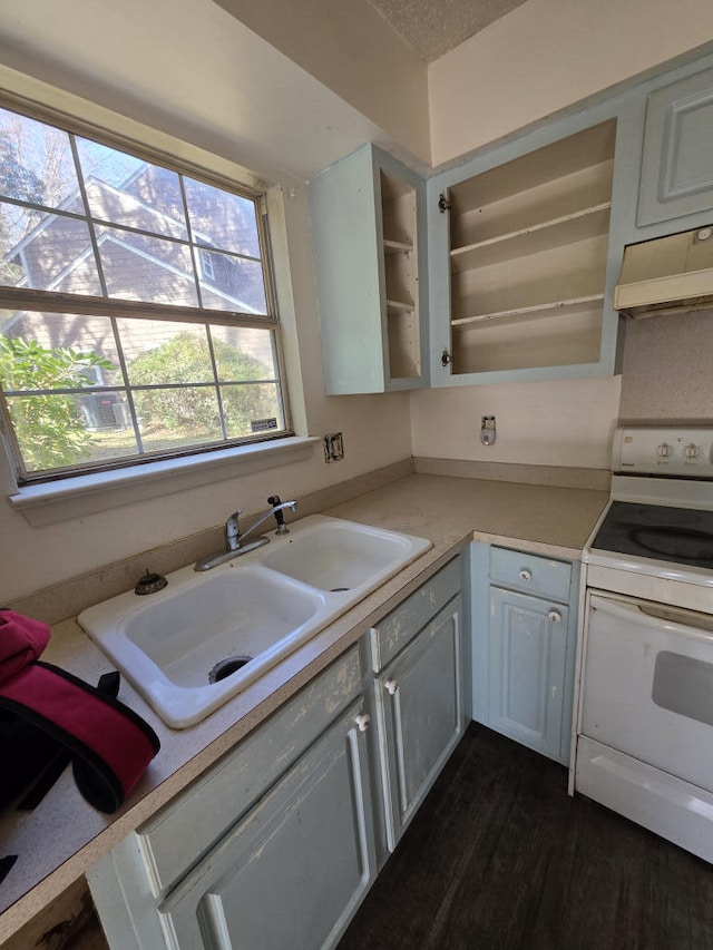 kitchen featuring a sink, under cabinet range hood, light countertops, and white electric range