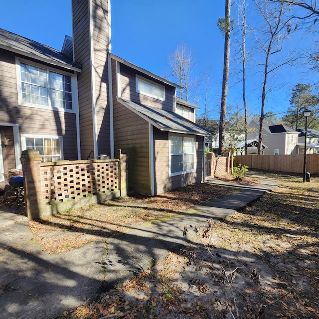 exterior space featuring fence and a chimney