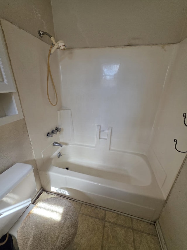 bathroom featuring tile patterned flooring, shower / bathing tub combination, and toilet