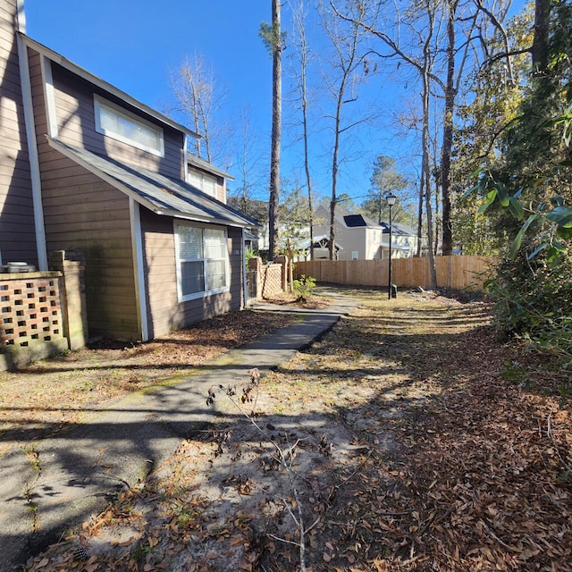 view of side of home featuring fence