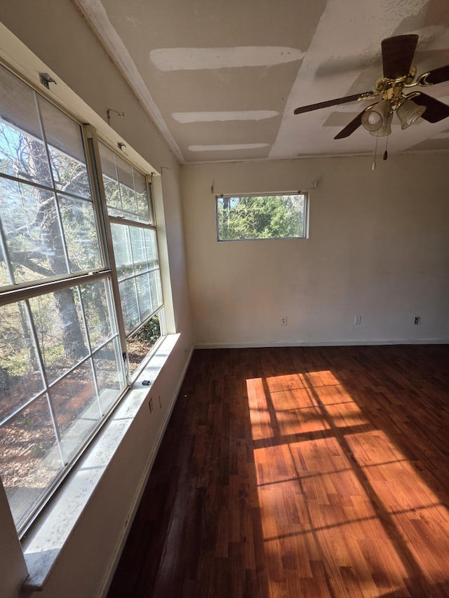 spare room featuring baseboards and wood finished floors