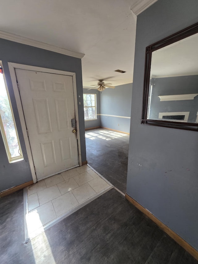 entrance foyer with baseboards, visible vents, ornamental molding, and a ceiling fan