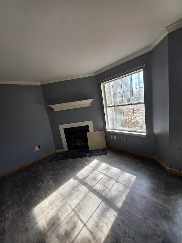 unfurnished living room featuring wood finished floors, ornamental molding, a fireplace with flush hearth, and baseboards