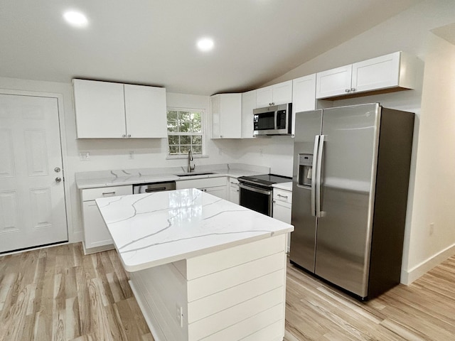 kitchen with appliances with stainless steel finishes, a center island, sink, and white cabinets