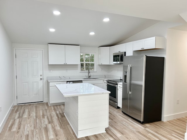 kitchen featuring sink, appliances with stainless steel finishes, light stone countertops, white cabinets, and a kitchen island