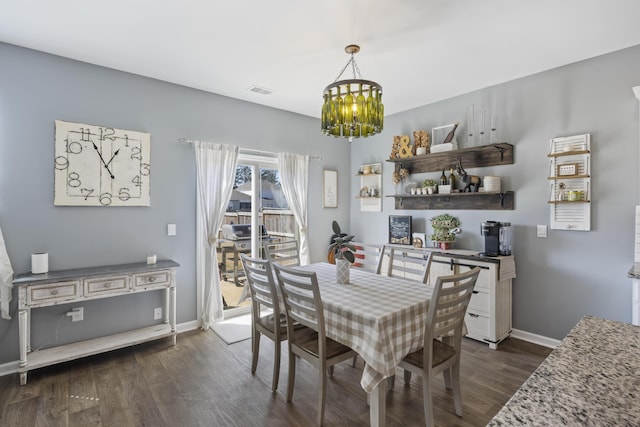 dining space featuring dark wood-style floors, baseboards, visible vents, and a notable chandelier