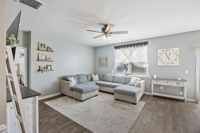 living room with dark wood-type flooring, visible vents, ceiling fan, and baseboards