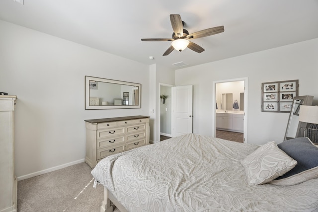 bedroom with ensuite bathroom, carpet flooring, a ceiling fan, visible vents, and baseboards