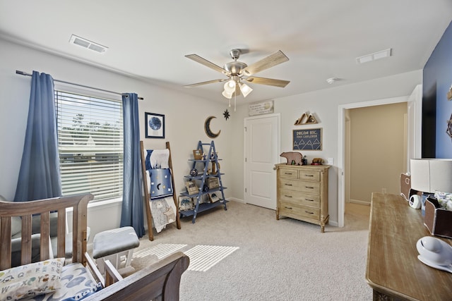 bedroom with light carpet, ceiling fan, visible vents, and baseboards