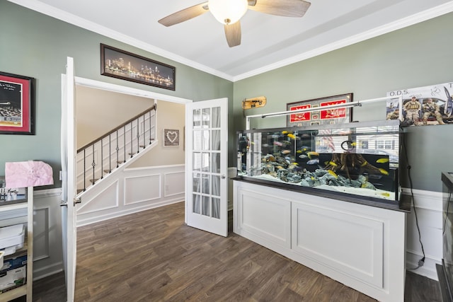 bar featuring dark wood-style floors, crown molding, a decorative wall, wainscoting, and stairs