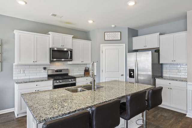 kitchen featuring visible vents, appliances with stainless steel finishes, dark wood-style flooring, and a sink