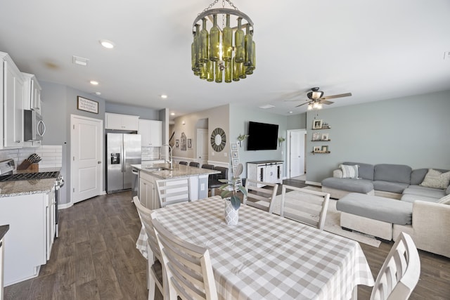 dining space with visible vents, ceiling fan with notable chandelier, dark wood finished floors, and recessed lighting