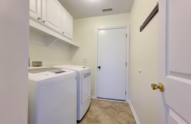 laundry room featuring a textured ceiling, visible vents, cabinet space, baseboards, and washer and dryer