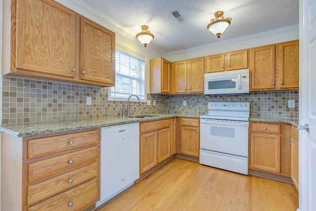 kitchen with visible vents, crown molding, light wood-type flooring, a sink, and white appliances