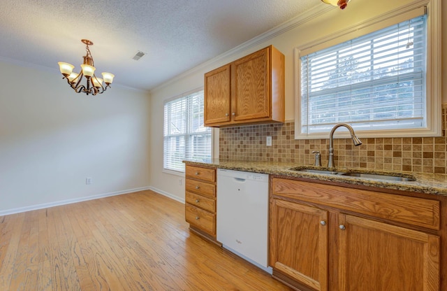 kitchen with a sink, dishwasher, light wood-type flooring, visible vents, and ornamental molding