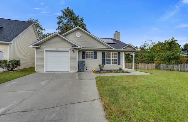 single story home with driveway, a chimney, solar panels, fence, and a front lawn