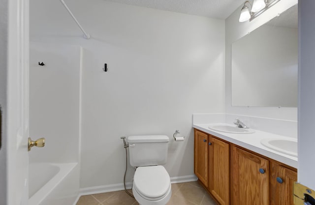 bathroom featuring double vanity, toilet, a sink, and tile patterned flooring