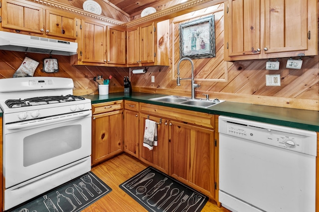 kitchen with light wood-style flooring, a sink, wooden walls, white appliances, and under cabinet range hood