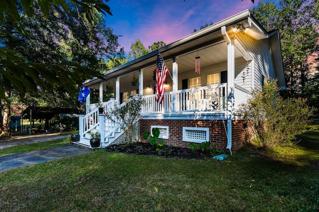 view of front of home with covered porch and a lawn