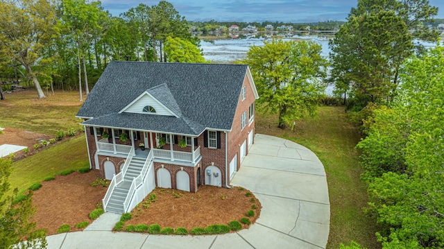 view of front of property with a porch, a water view, and a front yard