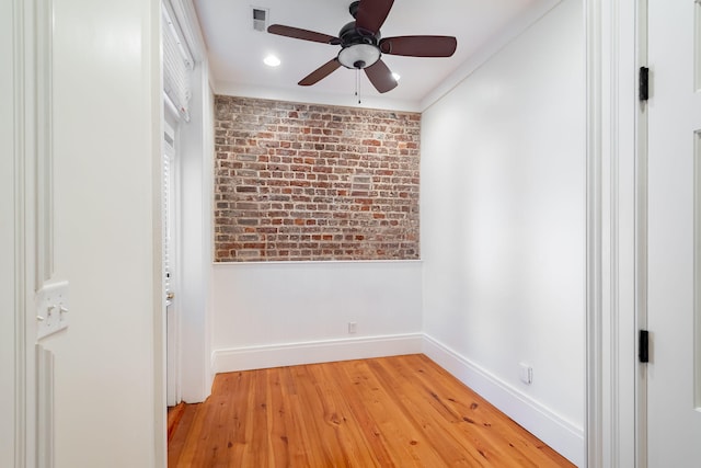 unfurnished bedroom with ceiling fan, brick wall, and light hardwood / wood-style flooring