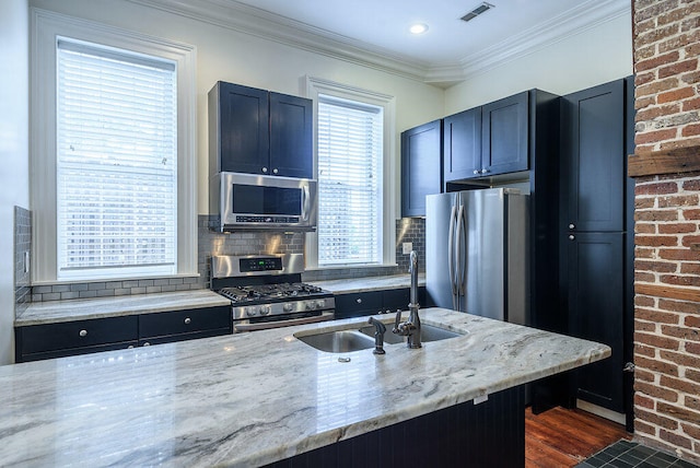 kitchen with dark wood-type flooring, light stone countertops, stainless steel appliances, and backsplash