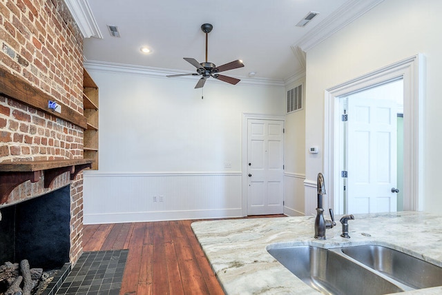 interior space with ornamental molding, sink, ceiling fan, and dark wood-type flooring