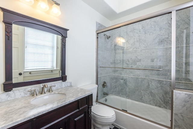 full bathroom featuring bath / shower combo with glass door, toilet, and vanity