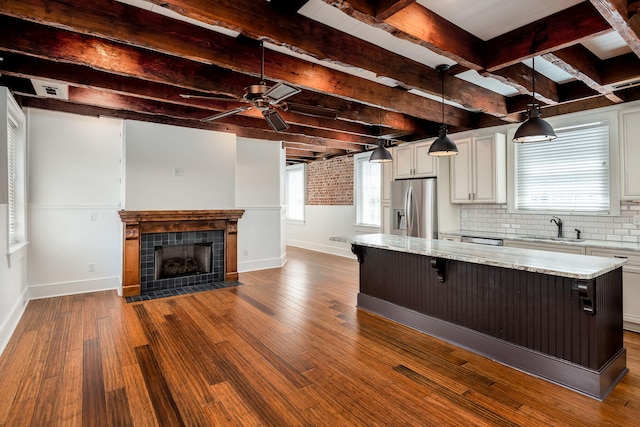 kitchen with a fireplace, decorative backsplash, hardwood / wood-style floors, sink, and appliances with stainless steel finishes