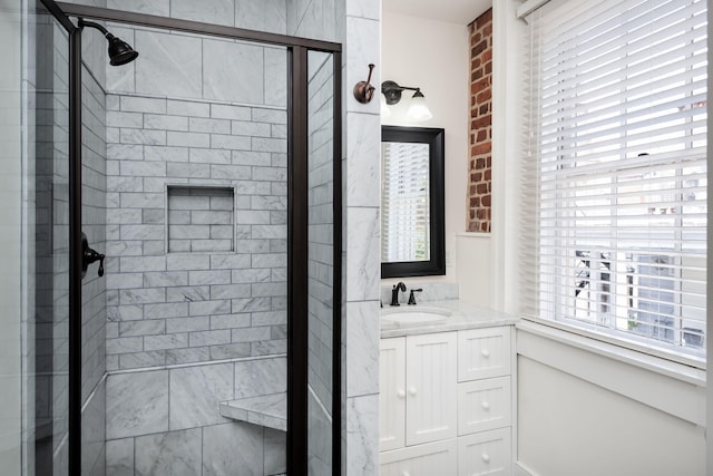 bathroom featuring a shower with shower door and vanity