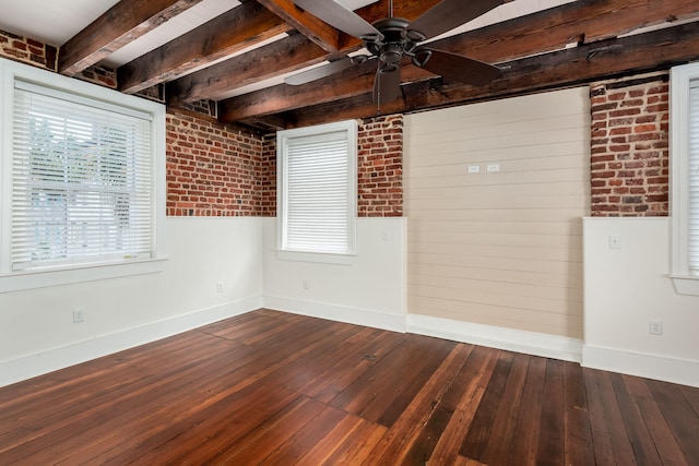 empty room with brick wall, beamed ceiling, dark hardwood / wood-style floors, and ceiling fan